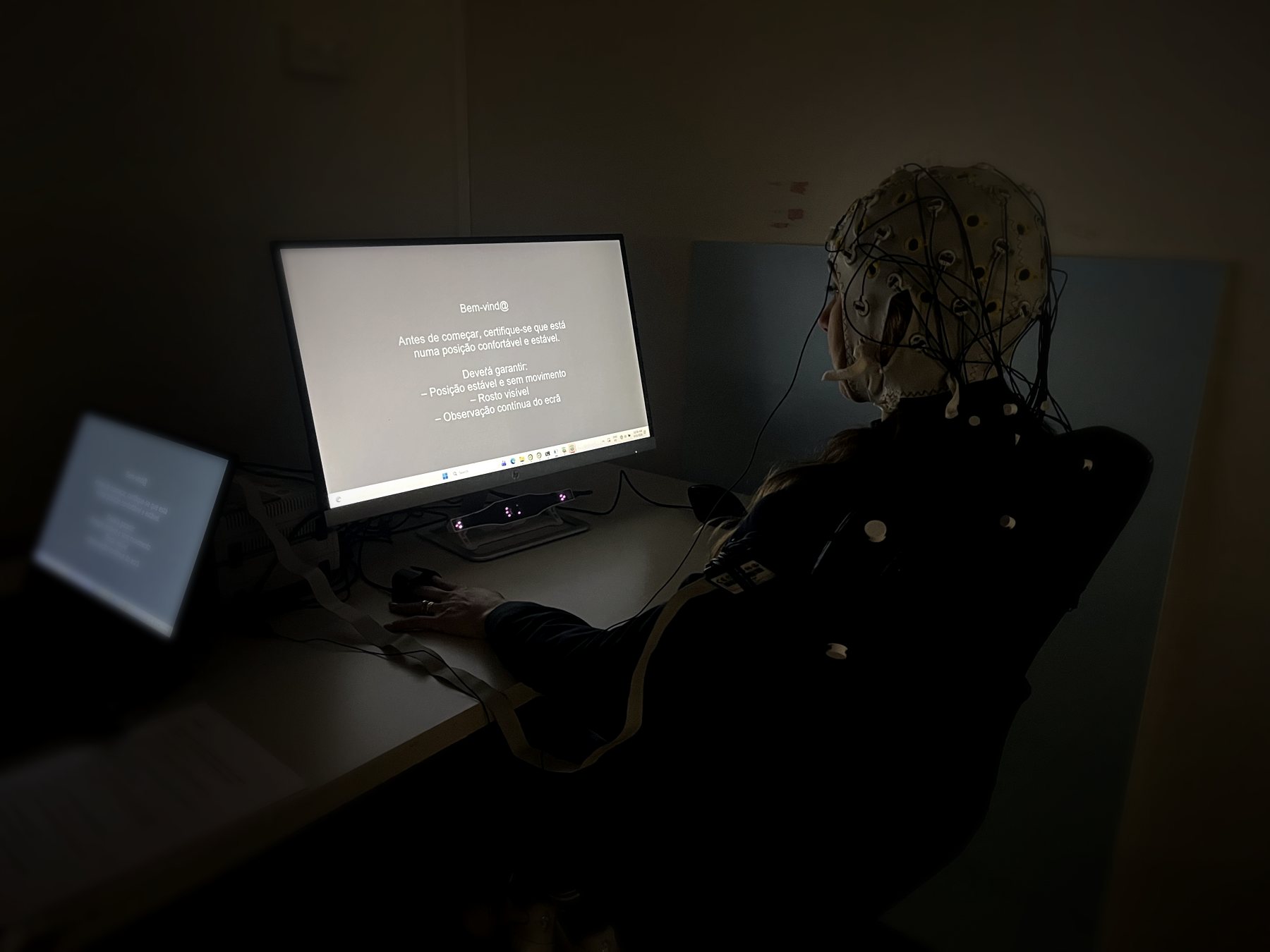 Participante com touca de EEG no laboratório da Brainding